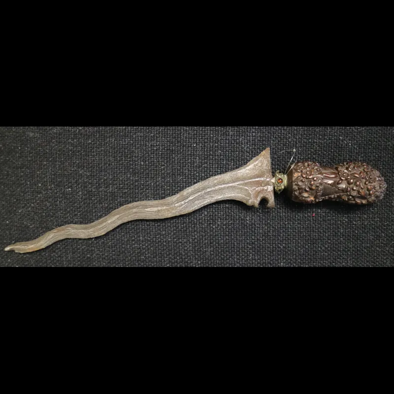 Keris knife from Madura, an island off the coast of Java, with intricately carved handle and inset gemstones.